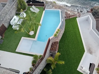 Jardín a doble altura con césped artificial y piscina en tenerife