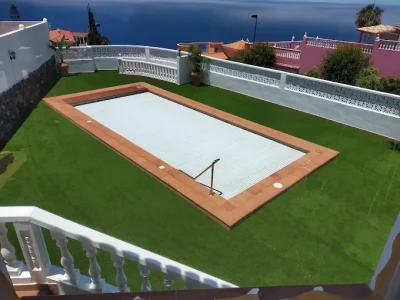 Piscina con césped artificial en jardín